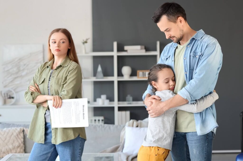 Girl hugging her father after divorce at home